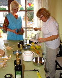 Karin und Renate mahlen die Kerne fein
